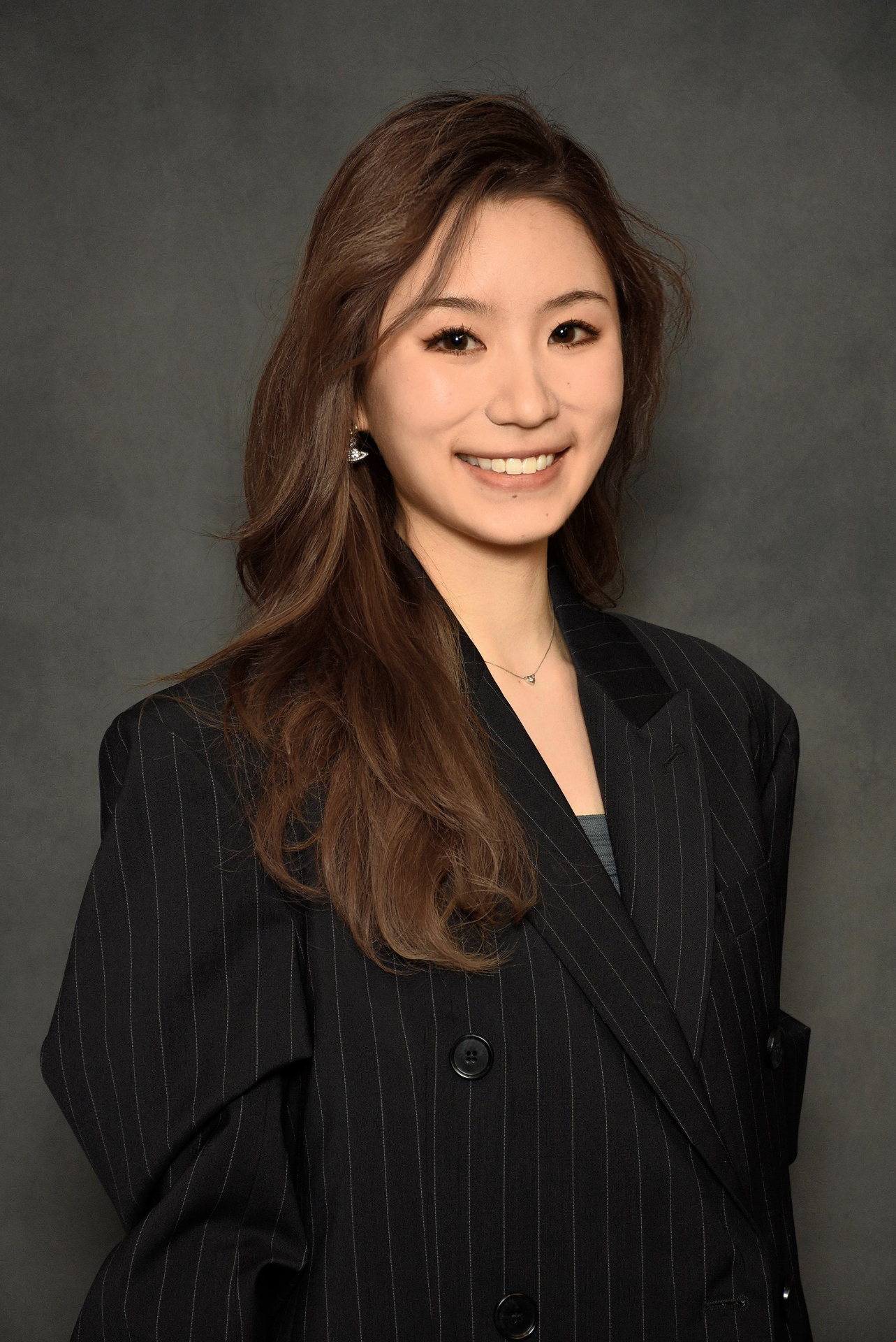 Portrait of Zoky Zhou in a dark pinstriped blazer
